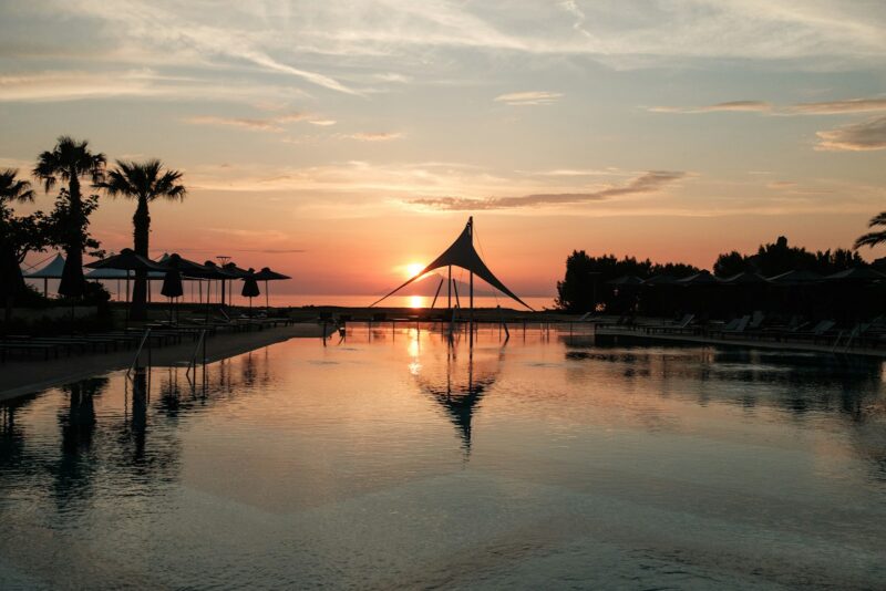 the sun is setting over a large pool